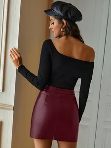 Macro view of a chic burgundy high-waisted PU leather mini skirt on a fashion model.
