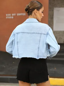 Detailed back view of a fashionable light blue cropped denim jacket featuring raw hem.