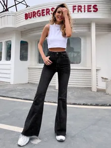 Model in stretch jeans met hoge taille en wijde pijpen in een stedelijke omgeving