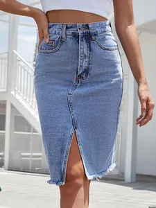 Dettaglio di gonna midi in denim a vita alta con spacco anteriore e orlo sfrangiato.