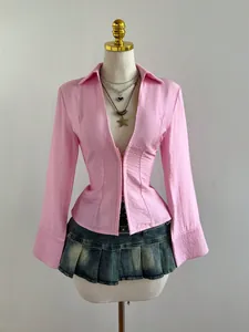 Dettaglio maglia rosa a righe a maniche lunghe con scollo a V su un manichino.
