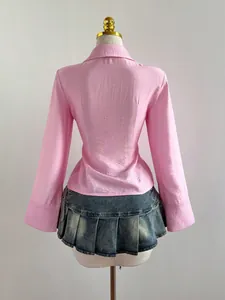 Vista posteriore di una camicia rosa aderente a maniche lunghe e minigonna di jeans a pieghe