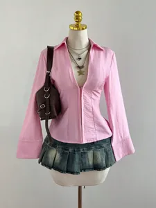 Dettaglio di camicia rosa a righe slim-fit con scollo a V su manichino professionale.