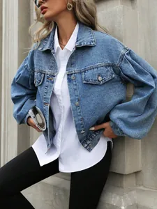 Dettaglio giacca in denim blu corta con maniche a sbuffo voluminose su una modella di moda