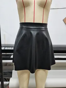 Dettaglio di una minigonna nera in pelle PU a vita alta con orlo a pieghe elegante.