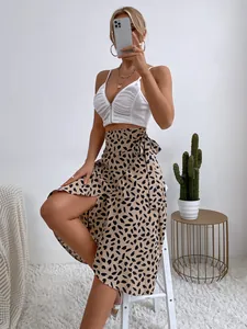 Elegante falda midi cruzada beige con lunares y abertura lateral en la modelo profesional