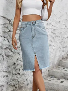 Dettaglio di gonna midi in denim azzurro a vita alta con spacco frontale e orlo a frange