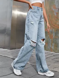 Vue détaillée d'un jean taille haute délavé clair avec genoux déchirés à la mode