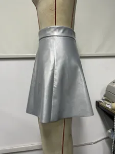 Dettaglio di minigonna in pelle PU argento a vita alta su manichino.