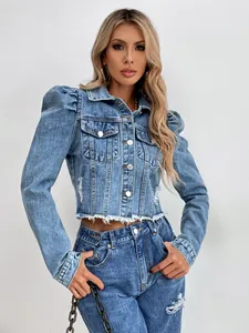 Détail d'une veste courte en jean bleu avec manches bouffantes et ourlet effiloché