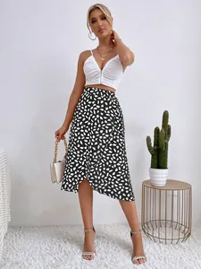 Elegante modelo con falda midi de lunares negros y diseño con abertura lateral.