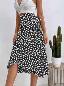 Elegante falda midi cruzada con lunares en blanco y negro y una abertura lateral