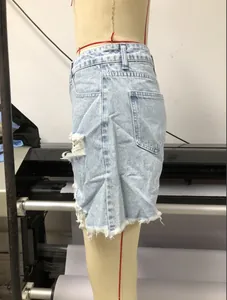 Vue latérale d'un short en jean taille haute délavé avec détails déchirés et ourlets effilochés