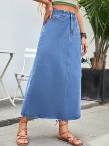 Close-up detail of a light blue high-waisted denim A-line midi skirt with raw hem