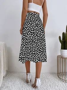 Vista trasera de una falda midi negra con estampados de pétalos blancos y talle alto