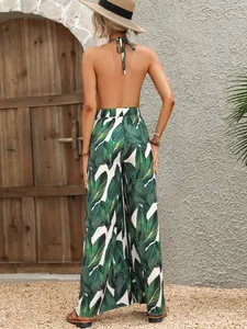 Rückansicht eines rückenfreien Neckholder-Jumpsuits mit tropischem Palmenblatt-Print