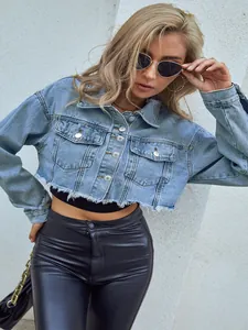 Close-up of a stylish light blue cropped denim jacket with frayed hem and metal buttons.
