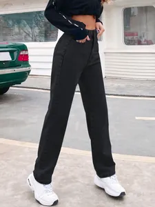 Stylish high waist black denim straight-leg trousers shown in an urban outdoor setting