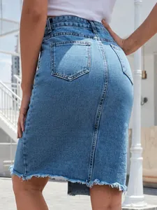 Dettaglio posteriore di una gonna a tubino in denim blu a vita alta con orlo a vivo sfilacciato.