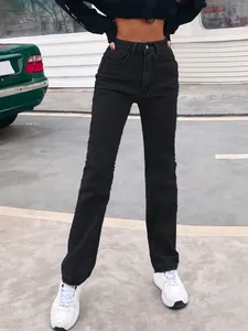Detail view of fashion high-waisted black straight-leg denim jeans on a model in street style