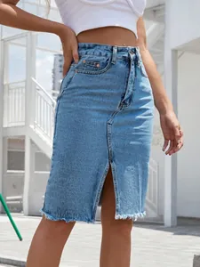 Dettaglio della gonna midi in denim a vita alta azzurra con spacco e orlo a vivo.