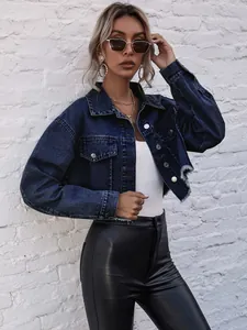 Close-up of a dark blue cropped denim jacket with distressed hem and silver buttons.