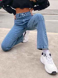 Full view of high-waisted blue denim straight-leg jeans on a model in urban setting