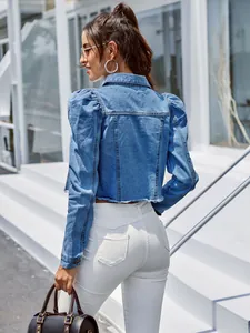 Veste en jean courte pour femme avec manches bouffantes et ourlet effiloché de couleur bleue.