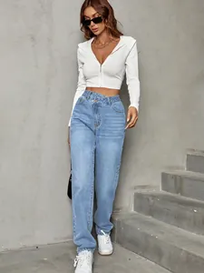 Model wearing stylish light blue high-waisted wide-leg jeans with asymmetric crossover waist.