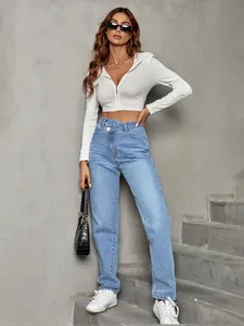 Detailed shot of high-waisted loose denim jeans with unique criss-cross waist design