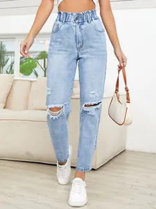 Close-up of stylish light blue high-waisted ripped straight leg jeans for women.