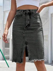 Dettaglio di una gonna in denim nero lavato a vita alta con spacco frontale e orlo