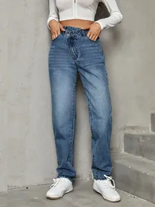 Detail of high-waisted denim pants featuring a unique asymmetrical button closure design.