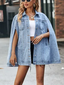 Detail view of a light wash oversized denim cape jacket with slit sleeves on model.