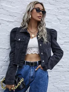 Veste en jean courte noire à manches bouffantes portée par un mannequin sur mur blanc