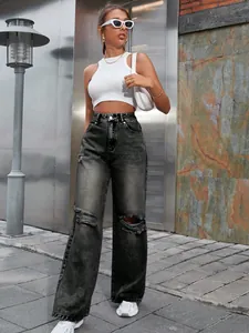 Détail style de rue d'un jean large à taille haute déchiré avec un délavage gris foncé denim
