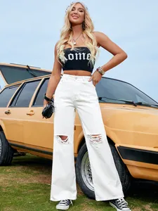 Vue détaillée du jean blanc déchiré à taille haute et jambe large avec fond de voiture.