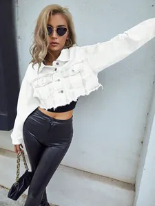 Detalle de una chaqueta vaquera corta blanca con detalles desgastados y bajo deshilachado.