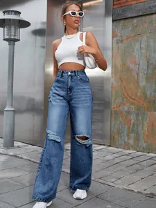 Vue d'un jean délavé taille haute à jambes larges dans un cadre urbain de rue moderne.