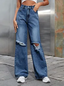 Gros plan sur un jean bleu taille haute à jambe large avec genoux déchirés tendance.