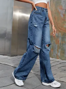 Détail d'un jean en denim bleu large à taille haute et déchirures pour femme moderne
