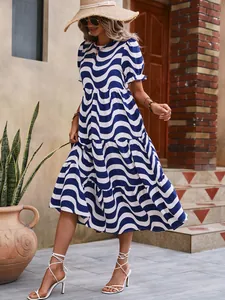 Close-up detail of a blue and white wave print puff sleeve smock dress in a sunny setting