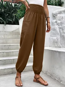 Gros plan d'un pantalon de jogging marron à taille haute élastique pour femme avec poche.