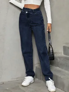 Model wearing high-waisted dark blue loose denim jeans with cross-over waist detail