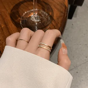 Elegante set di anelli minimalisti in oro sul dito, vista lifestyle di gioielli