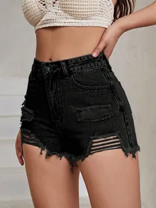 Detailed macro view of black ripped denim shorts with distressed raw edge hem finish