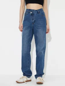 Detail of high-waisted loose denim jeans featuring a stylish asymmetric button closure