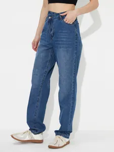 Detailed view of women's high-waisted loose denim jeans in classic blue wash