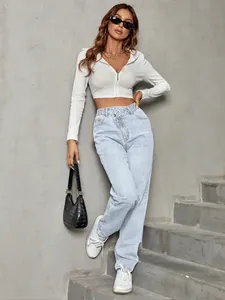 Detail of trendy high waisted light blue loose denim jeans with asymmetrical button fly
