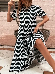 Detail view of a black and white wavy print maxi dress featuring puff sleeves and tiered skirt.